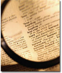 Dictionary with magnifying glass focusing on the word learn